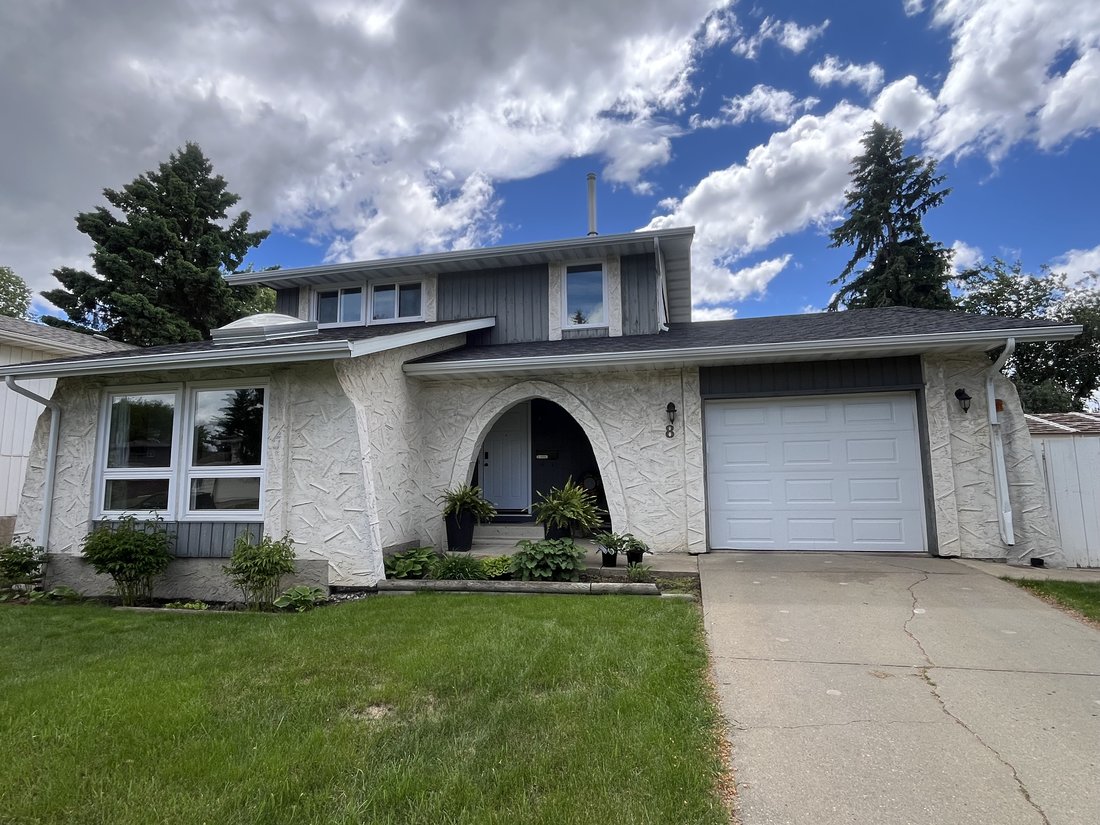 Same home before renovation with white stucco arched entry